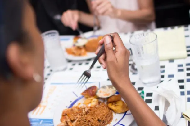 a person sitting at a table with a plate of food
