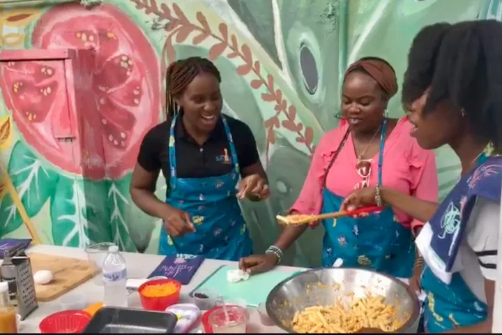 a group of people standing in front of a cake
