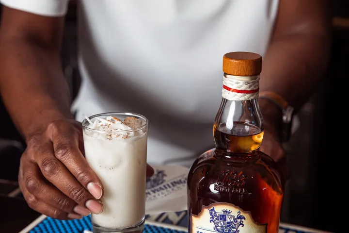 a man holding a glass of beer on a table