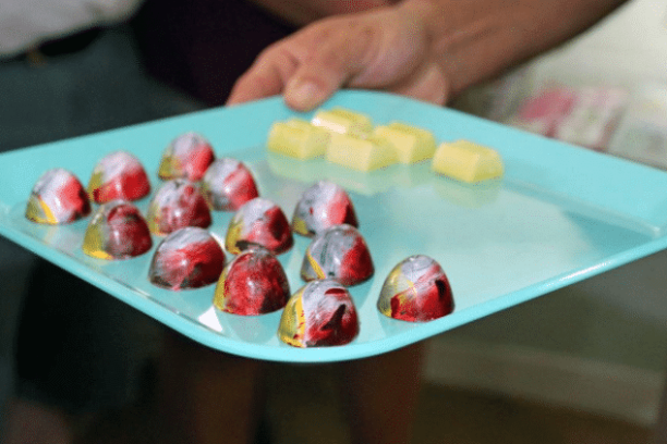 a person holding a plate of food on a table