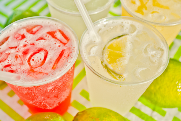 a close up of a bowl of fruit next to a cup of coffee